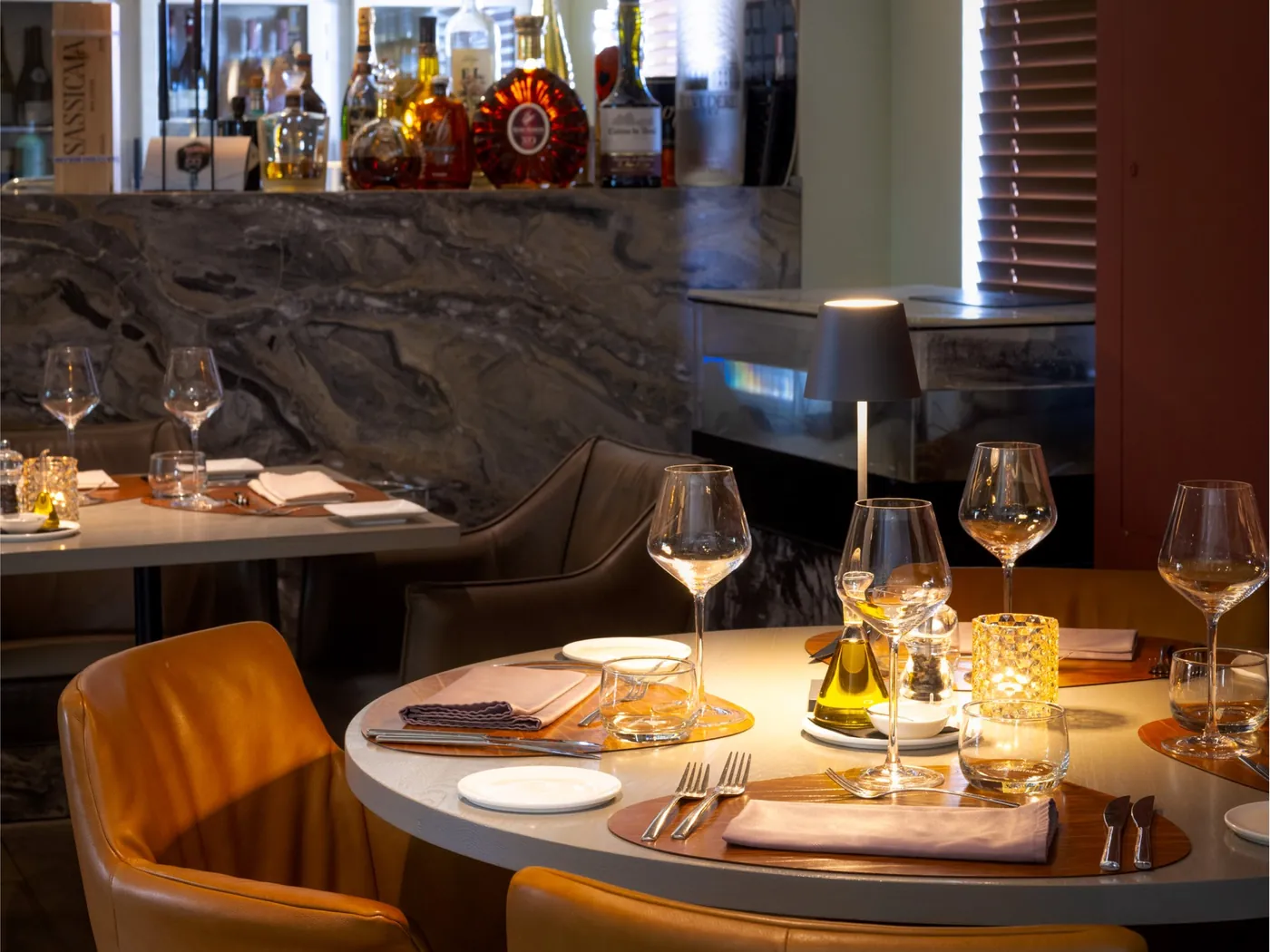 Ronde tafel bij de bar, gedekt en met een tafellamp aan