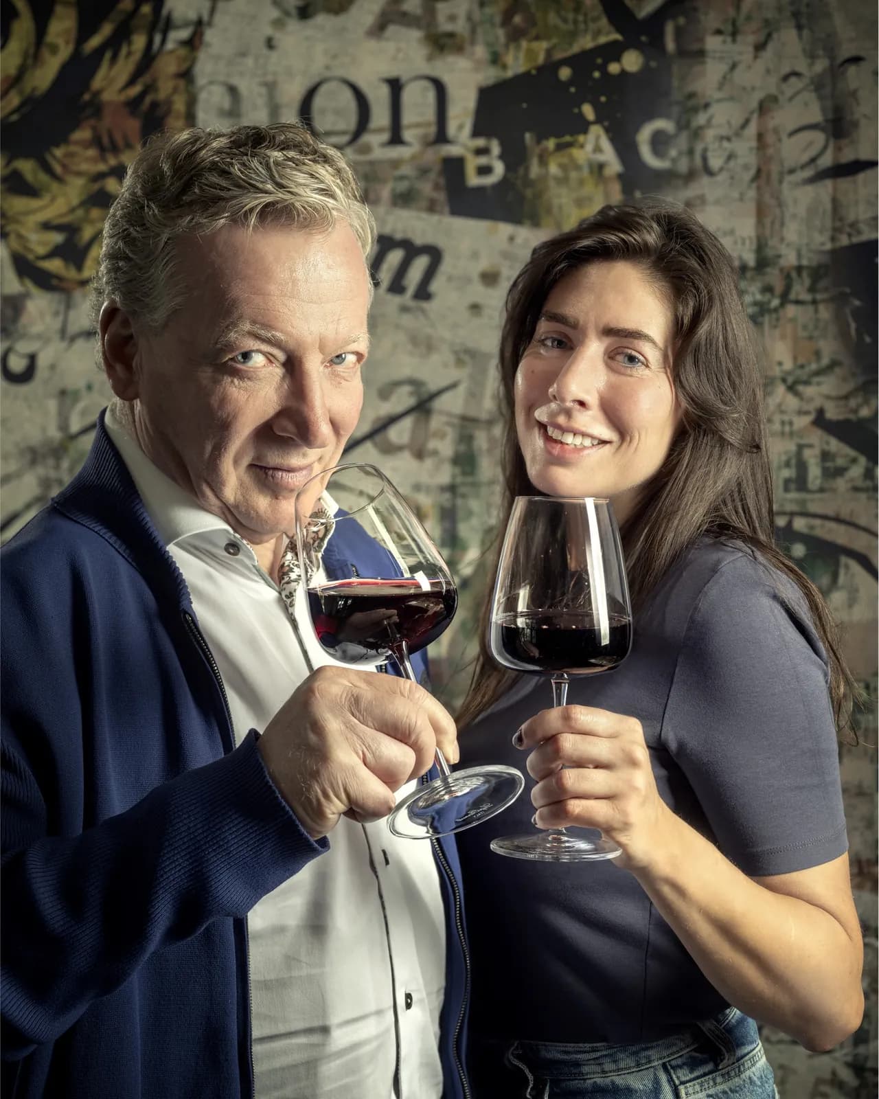 De gastheer en gastvrouw van Magnific proosten met een glas rode wijn